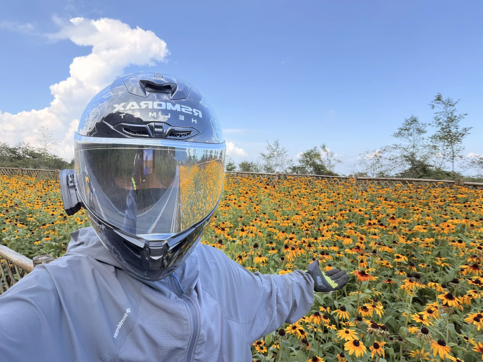 戴着头盔站在武陵山花海前的骑行者